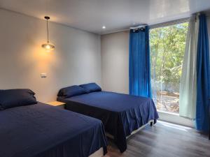 科马亚瓜Casavana的一间卧室设有两张床和窗户。
