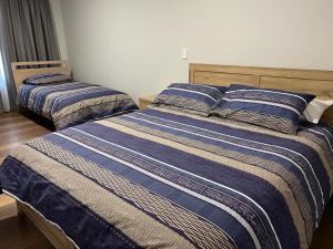 Swan ViewThe Morrison Motel的一间卧室配有两张带蓝白条纹床单的床