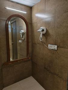 那格浦尔Hotel Heritage 2001, Nagpur的一间带镜子和吹风机的浴室