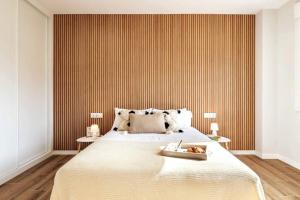 欧德鲁佐Apartamento White Tree by Arca Azahar的一间卧室设有一张带条纹墙的大床