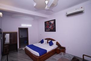 新德里Hotel Lecston @Yashobhoomi Dwarka Sector - 25 metro station的一间卧室配有一张床和吊扇