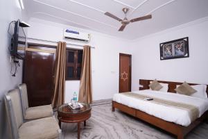 新德里Hotel Lecston @Yashobhoomi Dwarka Sector - 25 metro station的一间卧室配有一张床、一张桌子和一张沙发