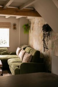 WeltonAkasha Spa Retreat Cottage的一间客厅,在房间内配有两张绿色沙发