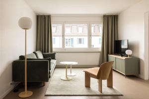 苏黎世EMA House Serviced Apartments Aussersihl的客厅配有沙发和桌子