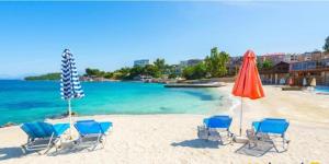 卡萨米尔BLUE HOTEL的海滩上的一组椅子和遮阳伞
