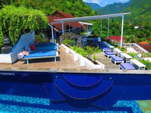 艾湄湾Waenis Sunset View Hotel and Restaurant, Amed, Bali的一个带蓝色躺椅的度假村游泳池