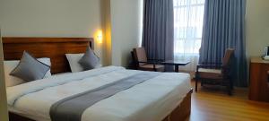 巴拉特布尔Hotel Gulmohar的一间卧室配有一张大床和一张桌子及椅子