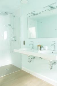 尼乌波特D’oude Dune的白色的浴室设有2个盥洗盆和淋浴。