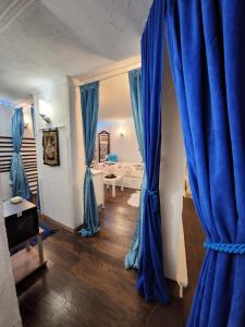 BrestovikSpa center Apartment Belgrad的一间设有蓝色窗帘的房间和一间配有床的房间