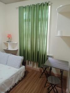Guinisilibanbucana traveler's inn的一间卧室配有床和绿帘