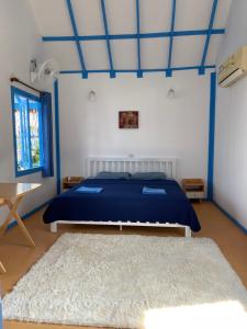 班泰Ko Phangan Beach Cottages的一间卧室配有蓝色的床和地毯