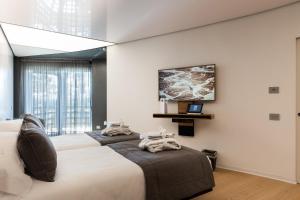 拉韦洛San Barbato Resort Spa & Golf的一间卧室设有两张床,墙上配有电视。