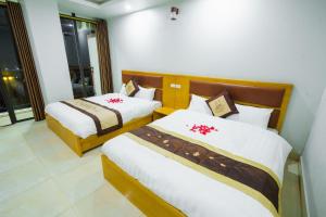 岑山UFJ HOTEL Sầm Sơn的一间卧室配有两张白色和棕色的床