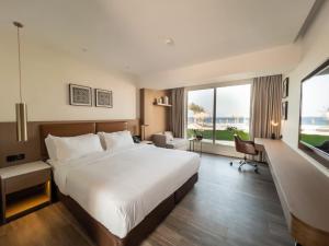 亚喀巴Luxotel Aqaba Beach Resort & Spa的一间酒店客房,设有一张大床和一个大窗户