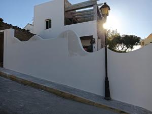 蓬塔翁布里亚Alhamar House with private pool的一条街道旁带灯杆的白色围栏