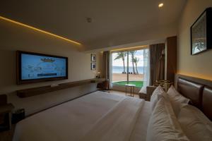 亚喀巴Luxotel Aqaba Beach Resort & Spa的酒店客房设有一张大床和一台电视。