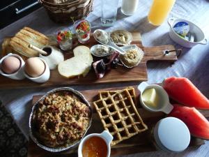 弗罗夏佩勒Chambre poésie的餐桌上摆着早餐食品、鸡蛋和华夫饼