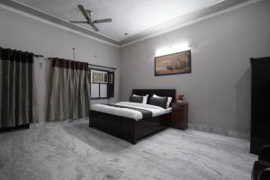 大诺伊达Sun flower Residency的一间卧室配有一张床和吊扇