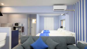 石垣岛Crice Hotel Ishigakijima的卧室配有蓝色和白色的床和沙发