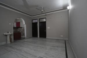 大诺伊达Sun flower Residency的一间空房间,设有两个黑色的门和水槽