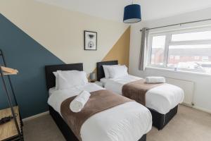 斯塔福德Perfect for Contractors & Families + Free Parking + Wifi的一间卧室设有两张床和窗户。