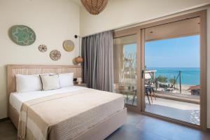 利迈纳里亚Castaway Suites - Studios Christos的一间卧室配有一张床,享有海景