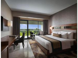 日惹日惹爱慕卡摩皇家酒店的酒店客房设有一张大床、一张书桌和一张书桌。