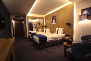 安曼Monarch Hotel Amman的酒店客房设有四张床和电视。
