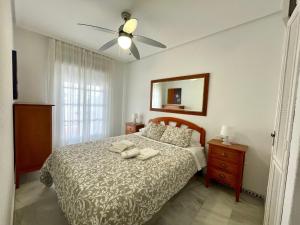 奇克拉纳－德拉弗龙特拉Apartamento Columela的一间卧室配有一张床和吊扇