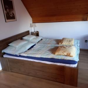 克塞洛Belvárosi Apartman Kőszeg的一张带木制床头板和枕头的床