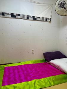 首尔Eugene Hanok Stay的一间设有一张带彩色毯子的床的房间