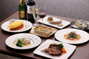 京都京都三条皇家花园酒店的餐桌,带食物盘和一瓶葡萄酒
