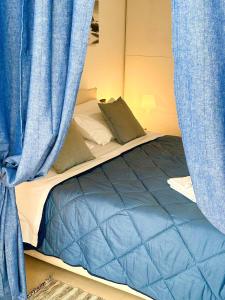 里米尼Giardino al mare的一张带蓝色窗帘的床