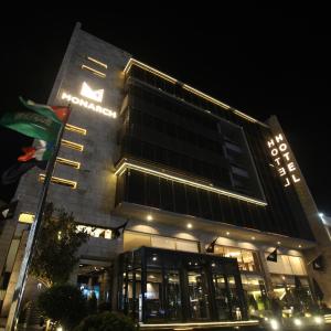 安曼Monarch Hotel Amman的一座晚上有标志的建筑