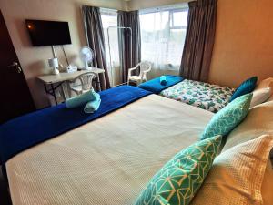 旺阿雷Denby Golf House Tikipunga的一间卧室配有两张带蓝色枕头的床