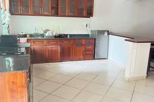 蒙巴萨Mombasa at your doorstep!的厨房配有木制橱柜和冰箱。