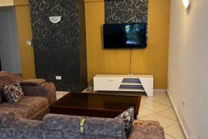 蒙巴萨Mombasa at your doorstep!的客厅配有2张沙发和1台平面电视