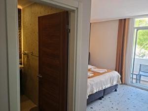 厄吕代尼兹托诺兹海滩酒店的一间卧室配有一张床,一扇门设有窗户