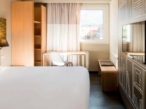 萨莱切Ibis Hôtel Sallanches的酒店客房设有床和窗户。