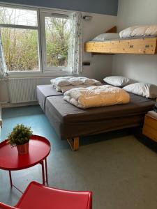 奥尔堡Danhostel Aalborg的客房设有两张双层床和一张红色的桌子。