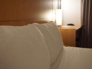 赫罗纳赫罗纳宜必思酒店的一张带白色枕头的床铺
