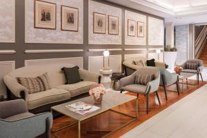 马德里加泰罗尼亚科尔特斯酒店的带沙发、椅子和桌子的客厅