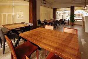 阿布贾Hamasville Boutique Hotel的用餐室配有木桌和椅子