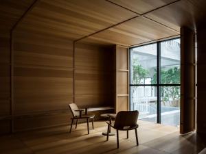前桥市SHIROIYA HOTEL的一间设有两把椅子、一张桌子和一个窗户的房间