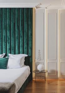 波尔多Hôtel Singulier Bordeaux的一间卧室设有绿色的墙壁、一张床和一张桌子