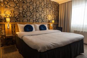 瓦斯泰纳Starby Spa, Hotell & Konferens的一间卧室配有一张带蓝色枕头的大床