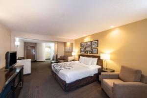 De PereSleep Inn & Suites Green Bay South的大型酒店客房设有床和电视。