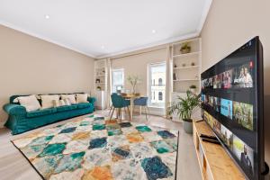 伦敦Battersea Bridge Ultra Central London One Bedroom Apartment 10 mins walk to Kings Road Chelsea的客厅配有蓝色的沙发和电视