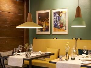 巴特塞森多夫Hotel Schnitterhof的用餐室配有2张桌子和椅子以及灯光