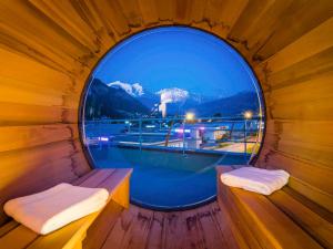 萨莱切Ibis Styles Sallanches Pays du Mont-Blanc的木制客房的圆形窗户,享有美景
